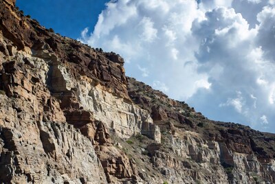 Layered Rock Cliff Under Blue Sky
