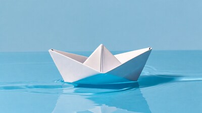 White paper boat on blue water