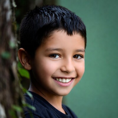 Smiling boy peeking through vines