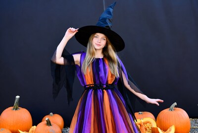 Girl in witch costume with pumpkins