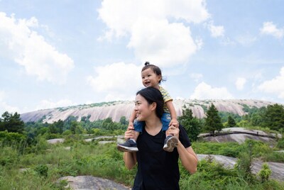 Asian mother piggybacking baby at Stone Mountain