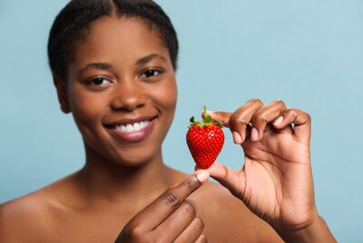 African-American woman holding strawberry