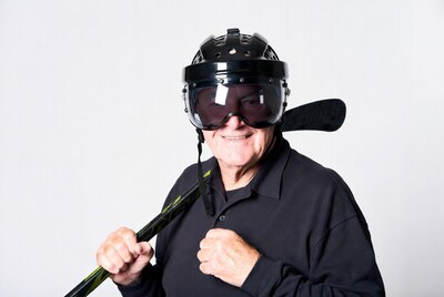 Senior man with hockey helmet and stick