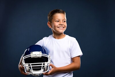 Boy holding football helmet