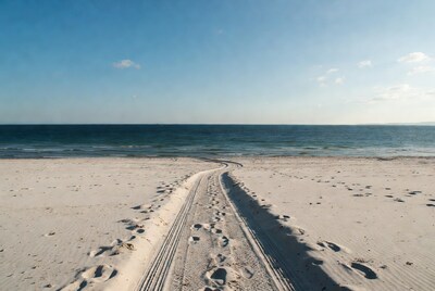 Tire Tracks and Footprints on Beach to Ocean