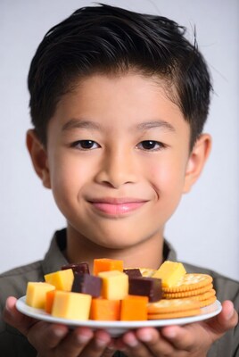 Asian boy holding cheese and crackers