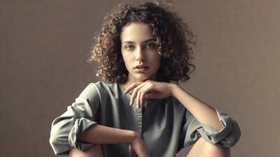 Woman with curly hair in gray shirt