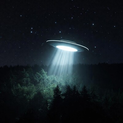UFO beaming light over forest