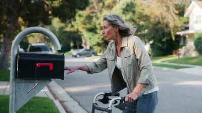 Elderly woman checking mailbox with walker