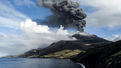 Erupting Volcano Over Black Sand Beach