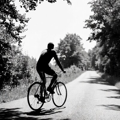 Man biking on rural road silhouette