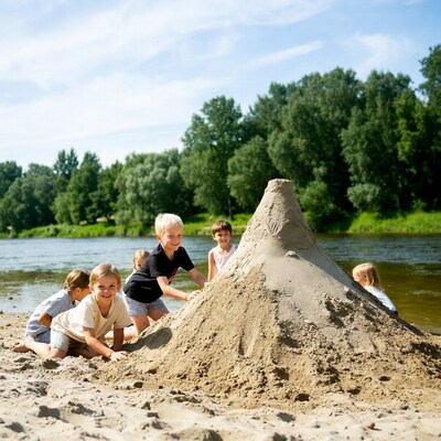 Children building sandcastle on river beach