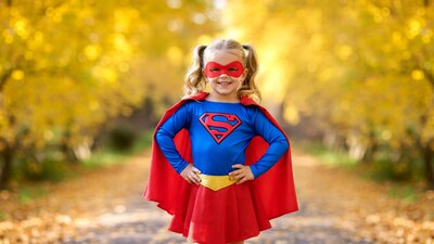 Girl in Supergirl costume autumn path
