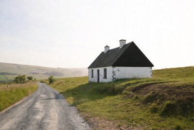 White cottage on grassy hillside