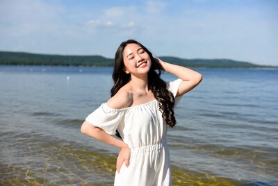 Asian woman smiling by lake