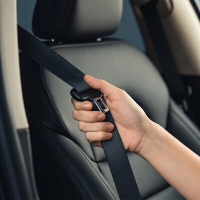 Hand buckling seatbelt in car