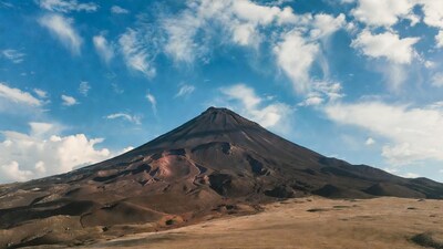 Volcanic cone mountain under blue sky