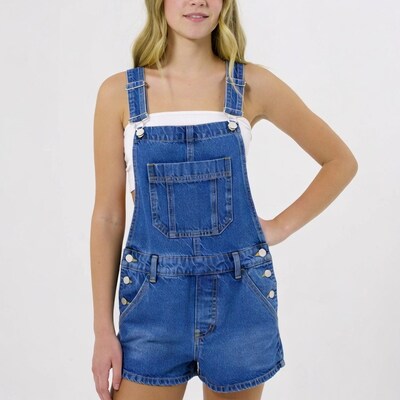 Teen girl in blue denim overall shorts