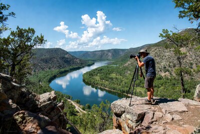 Man photographing river from cliff