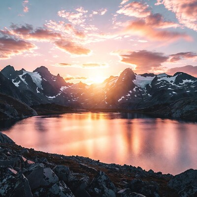 Sunrise over snowy mountains and lake