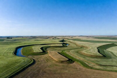 Aerial view of meandering river in green fields