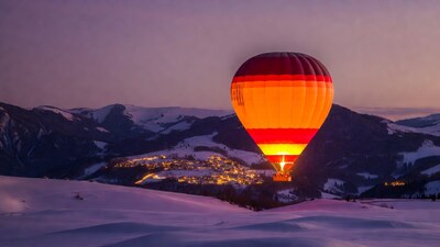 Hot air balloon over snowy mountains
