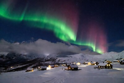 Aurora Borealis over snowy cabins