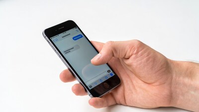 Hand holding iPhone typing message