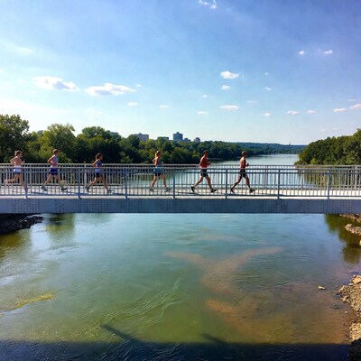 Runners jogging on bridge over river
