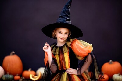 Girl in witch costume with pumpkins