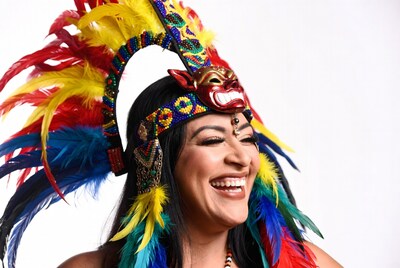 Woman in colorful feathered headdress smiling