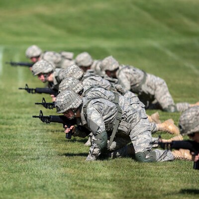 Soldiers prone firing rifles on grass