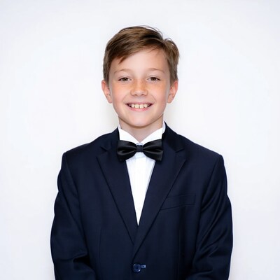 Boy in navy tuxedo smiling