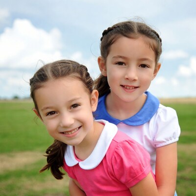 Two smiling girls in field