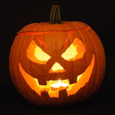 Lit Jack-o'-lantern pumpkin on black background