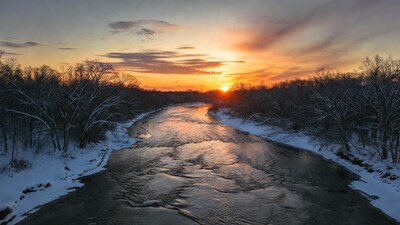 Frozen River at Sunset with Snowy Trees