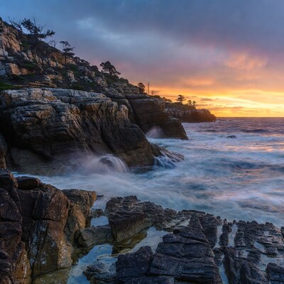 Ocean Waves Crashing on Rocky Cliffs at Sunset