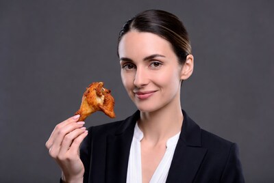 Woman holding fried chicken wing