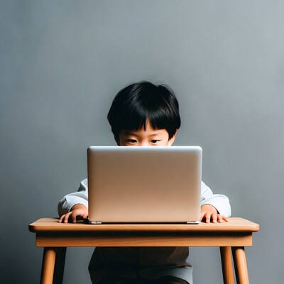 Asian boy using laptop at table