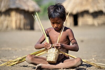 Young Asian boy weaving basket