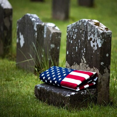 American flag on gravestone in cemetery