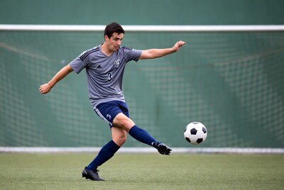 Man kicking soccer ball at goal