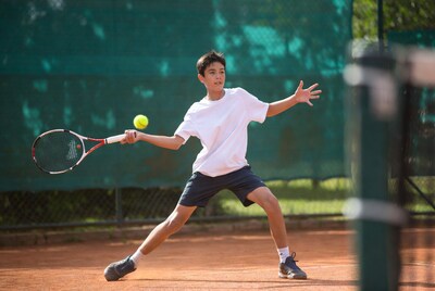 Boy hitting tennis ball