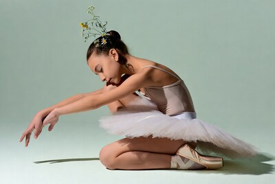 Ballerina girl kneeling with flowers in hair