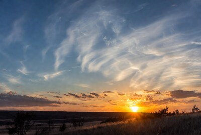 Sunset over grassy prairie landscape