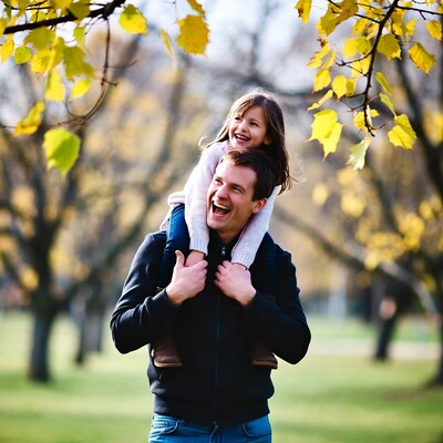 Father carrying smiling daughter on shoulders