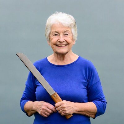 Elderly woman holding bread saw