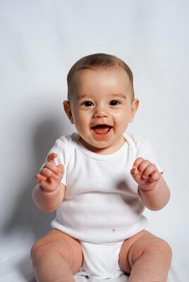 Baby boy laughing in white onesie