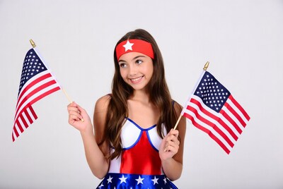 Girl holding American flags in patriotic costume