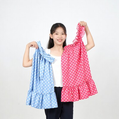 Asian girl holding blue and pink polka dot dresses